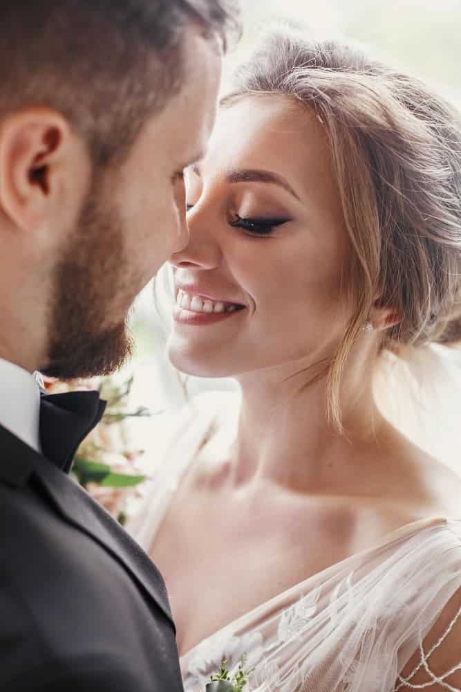 gorgeous bride stylish groom gently hugging embracing window light sensual wedding couple smiling light happy romantic moments newlyweds wedding photo
